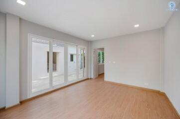 Spacious living room with large windows and wooden flooring