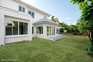 Exterior view of a modern two-story white house with a spacious backyard