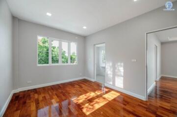 Bedroom with wooden flooring and large windows