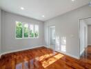 Bedroom with wooden flooring and large windows