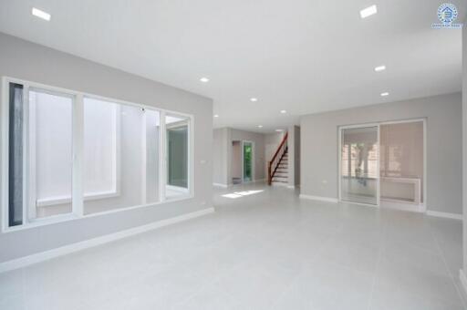 Spacious modern living room with large windows and staircase