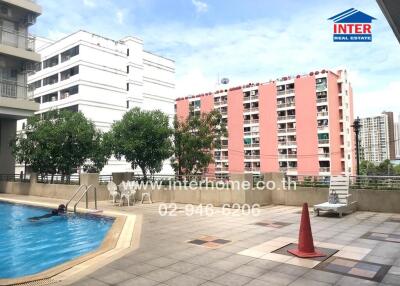Outdoor swimming pool area in an apartment complex with city view