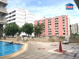 Outdoor swimming pool area in an apartment complex with city view