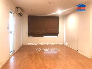 Spacious living room with wooden flooring and large window