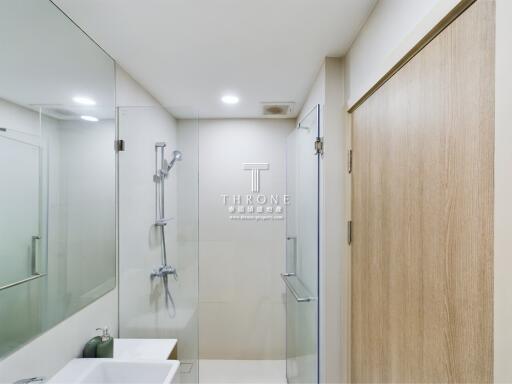 Modern bathroom with glass shower and wooden door