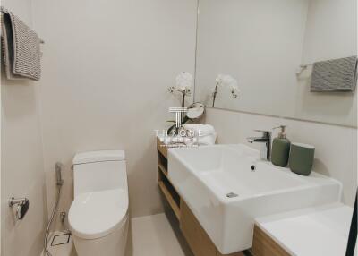 Modern bathroom with sink, toilet, and towel racks