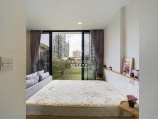 Spacious bedroom with a large window and modern decor