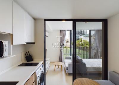 modern living area with kitchen and adjoining bedroom