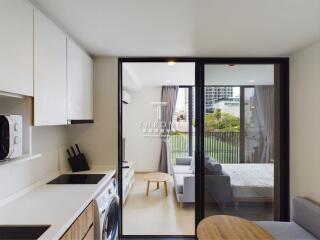 modern living area with kitchen and adjoining bedroom