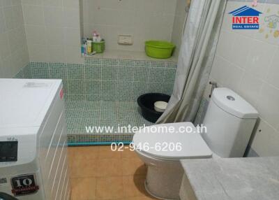 Bathroom with shower, washing machine, and toilet