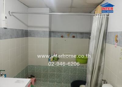 Clean bathroom with tiled walls and a shower curtain