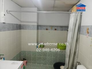 Clean bathroom with tiled walls and a shower curtain