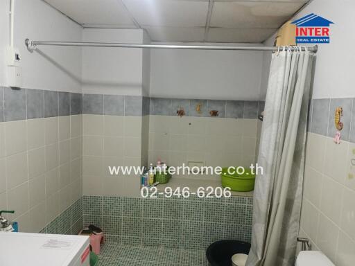 Clean bathroom with tiled walls and a shower curtain