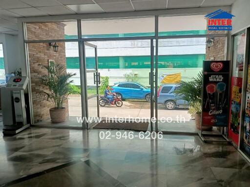 Entrance of a building with glass doors and plants