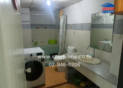 Bathroom with washing machine and sink