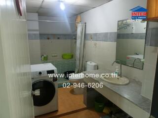 Bathroom with washing machine and sink