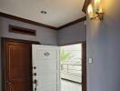 Well-lit entryway with wooden and white doors