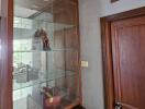 Wooden cabinet with glass shelves and a door in a living area