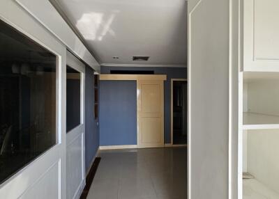 Spacious hallway with white and blue walls, and built-in storage