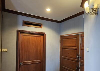 Photo of a residential entryway with wooden doors and tiled floor