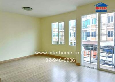 Spacious living area with large windows and balcony access