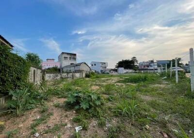 Empty lot with surrounding buildings and vegetation