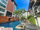 Outdoor view of a modern apartment complex with a swimming pool and tropical landscaping