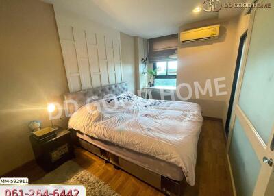 Cozy bedroom with a double bed, wooden floors, and air conditioning.