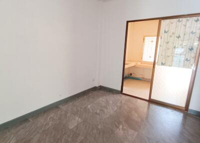 Empty room with tiled floor and sliding glass door to a sunlit area