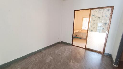 Empty room with tiled floor and sliding glass door to a sunlit area