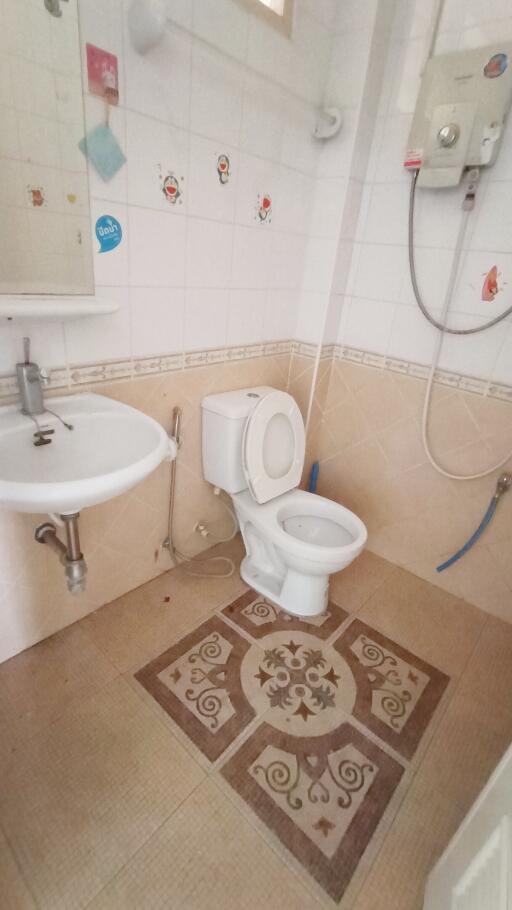 Well-maintained bathroom with sink, toilet, and water heater