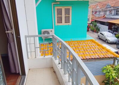 Small balcony with railing overlooking neighboring houses