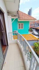 Small balcony with railing overlooking neighboring houses