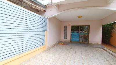 Carport area with tiled flooring and a metal gate