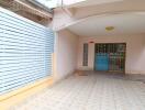 Carport area with tiled flooring and a metal gate