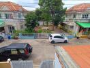 Street view of a residential neighborhood with several houses and parked cars