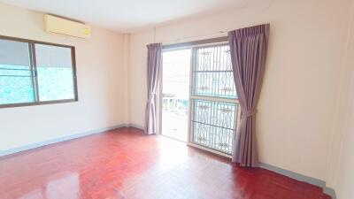 Bright bedroom with wooden floor and large window