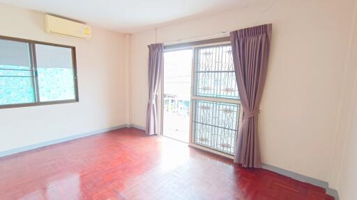 Bright bedroom with wooden floor and large window