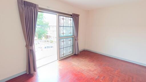 Bright bedroom with large window and hardwood floor