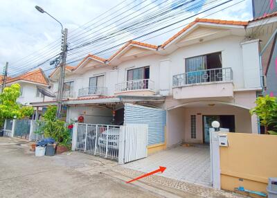 Exterior view of a multi-level house with a driveway and gated entrance