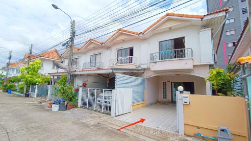 Exterior view of a multi-level house with a driveway and gated entrance