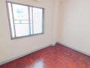 empty bedroom with wooden floor and window