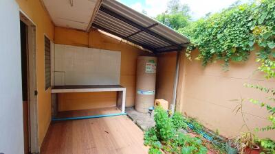 Covered outdoor area with water tank and greenery