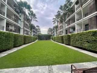 Outdoor view of modern residential building with a manicured lawn and hedges