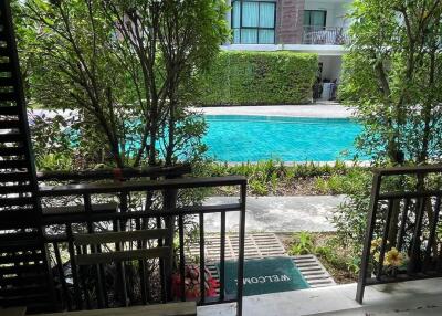 View of a swimming pool and apartment building from a patio area