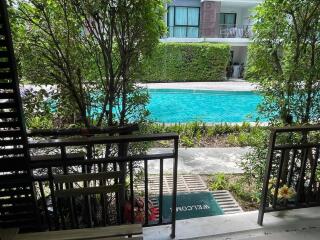 View of a swimming pool and apartment building from a patio area