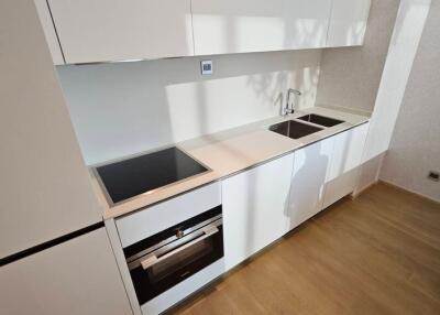 Modern minimalist kitchen with white cabinetry and wooden flooring