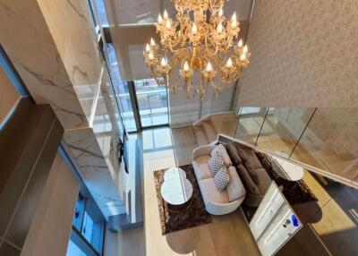 Living room with chandelier, large windows, and modern furnishings