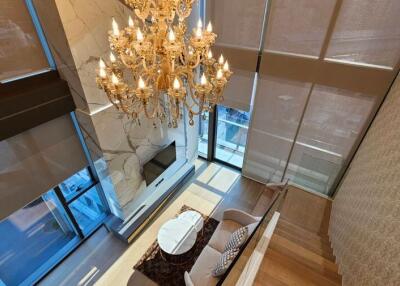 Spacious and elegant living room with chandelier and floor-to-ceiling windows