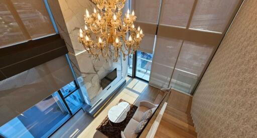 Spacious and elegant living room with chandelier and floor-to-ceiling windows